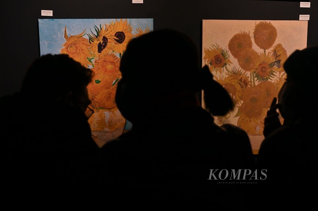 Pengunjung berbincang di depan lukisan karya pelukis legendaris Vincent Willem van Gogh dalam pameran interaktif Van Gogh – The Immersive Experience di London, Inggris, Jumat (1/4/2022). Melalui pameran tiga dimensi ini, pengunjung diajak mengenal sisi lain sang pelukis sekaligus menari bersama imajinasi Van Gogh.