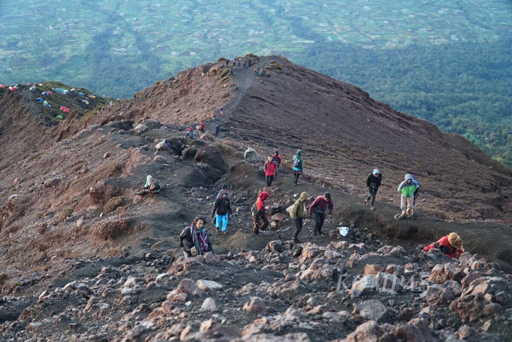 Para pendaki menuju puncak Gunung Kerinci untuk berburu matahari terbit dan menikmati pemandangan alam di Kabupaten Kerinci, Jambi, pada 1 Januari 2020.