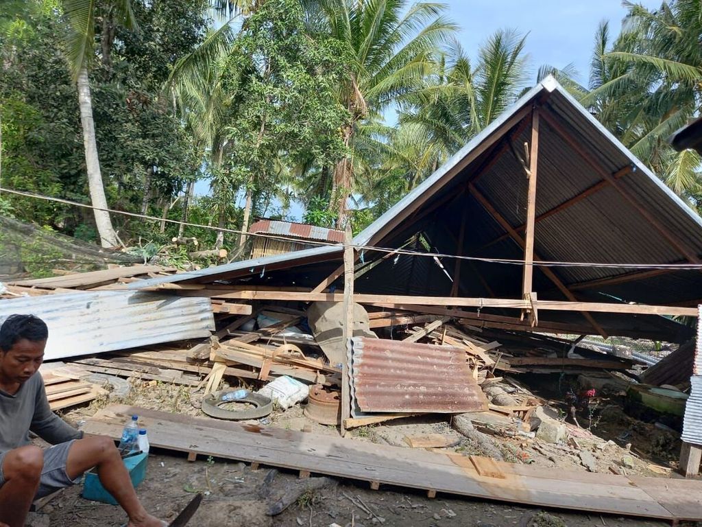 Seorang warga duduk di depan rumahnya yang ambruk akibat terjangan angin kencang di Kabupaten Sidrap, Sulawesi Selatan, Selasa (22/2/2022). Sedikitnya 87 rumah rusak akibat bencana ini.