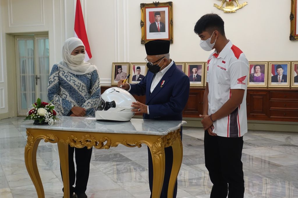 Wakil Presiden Maruf Amin menandatangani helm yang nantinya akan dikenakan pembalap muda Mario Suryo Aji yang merupakan satu-satunya pembalap Indonesia yang lolos pada Grand Prix Moto3 musim 2022 di Istana Wapres, Sabtu (22/1/2022).