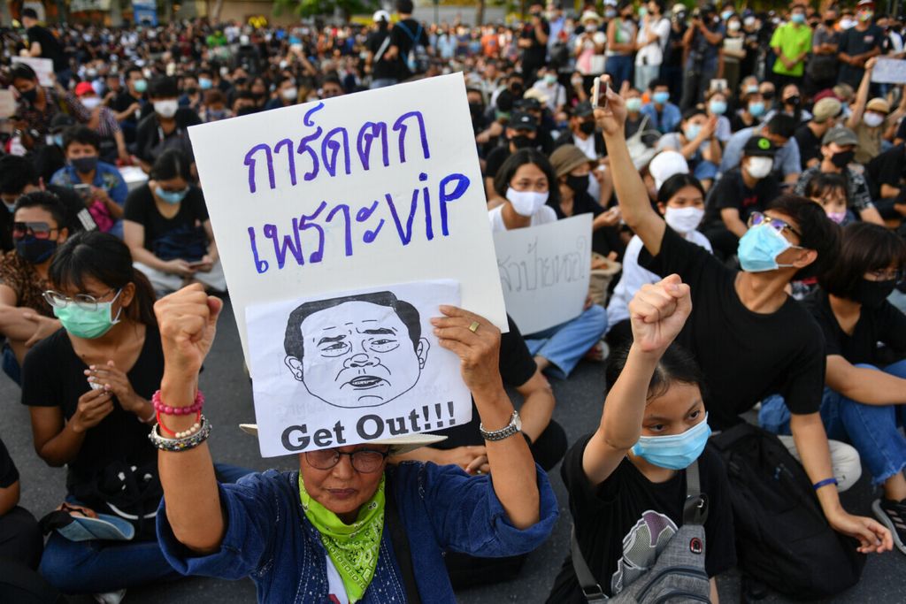 Pengunjuk rasa mengangkat poster bergambar sketsa kartun Perdana Menteri Thailand Prayuth Chan-ocha dalam unjuk rasa mendesak mundurnya pemerintahan di Bangkok, Thailand, 18 Juli 2020. 