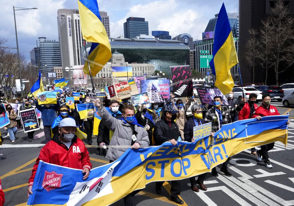 Orang-orang berbaris selama pawai menentang invasi Rusia ke Ukraina di dekat Kedutaan Rusia di Seoul, Korea Selatan, Minggu, 20 Maret 2022. 