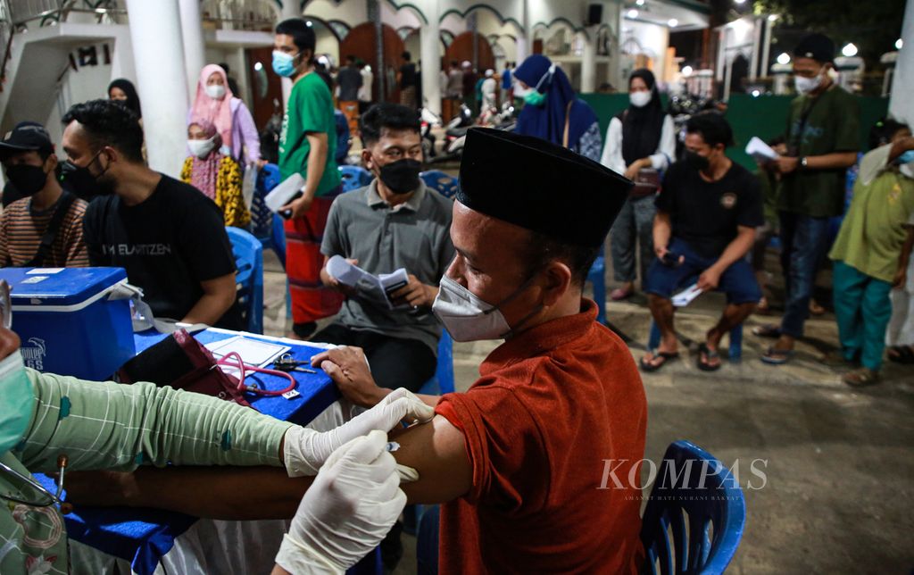 Warga menerima suntikan vaksin <i>booster </i>atau penguat di gerai vaksinasi presisi yang digelar di Masjid Al-Ikhlas, Larangan Selatan, Larangan, Kota Tangerang, Banten, Sabtu (9/4/2022) malam. Pemerintah mengumumkan vaksin dosis lengkap dan satu kali vaksin penguat menjadi syarat mudik Lebaran.
