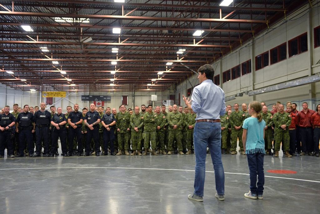 Dengan memakai celana jins, PM Justin Trudeau, didampingi anak perempuannya, Ella-Grace, berpidato di depan anggota Angkatan Bersenjata Kanada, Kepolisian Kanada, dan Badan Pemadam Kebakaran di Williams Lake, British Columbia, Kanada, Senin (31/7).