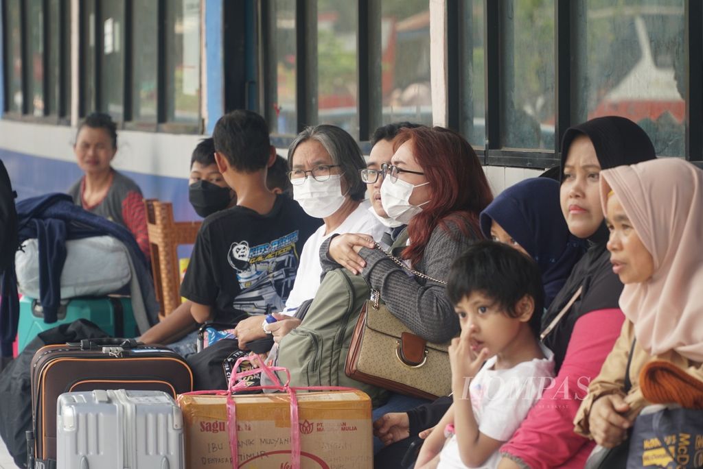 Penumpang duduk di ruang tunggu keberangkatan bus di Terminal Kampung Rambutan, Jakarta Timur, Senin (18/12/2023).  