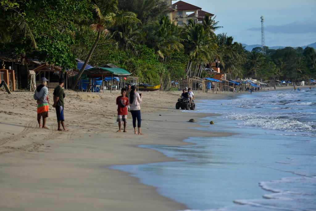 Pengunjung menikmati waktu sore di Pantai Anyer Sambolo I, Kabupaten Serang, Banten, Jumat (7/4/2023).