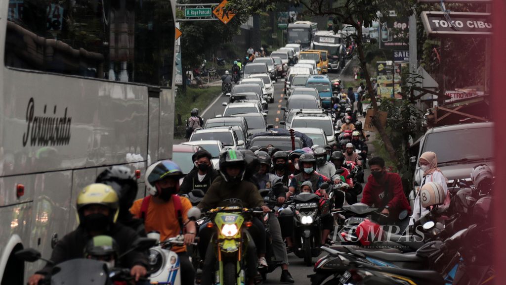 Suasana lalu lintas Jalan Raya Puncakdi Cisarua, Kabupaten Bogor, Jawa Barat, saat diberlakukan sistem satu arah karena ramai pelancong saat libur akhir pekan, Minggu (13/2/2022). 