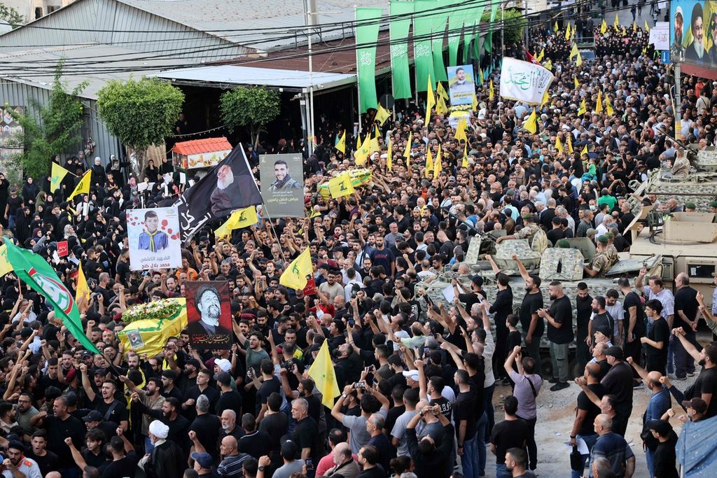 Warga mengiringi pemakaman jenazah korban ledakan ratusan penyeranta di Lebanon yang terjadi Selasa (17/9/2024). Dalam prosesi pemakaman, kembali terjadi rangkaian ledakan yang kali ini menimpa gawai <i>walkie talkie</i> dan aneka perlengkapan rumah warga di Lebanon yang menggunakan panel tenaga surya, Rabu (18/9/2024). Sebagian korban tewas adalah anak-anak.