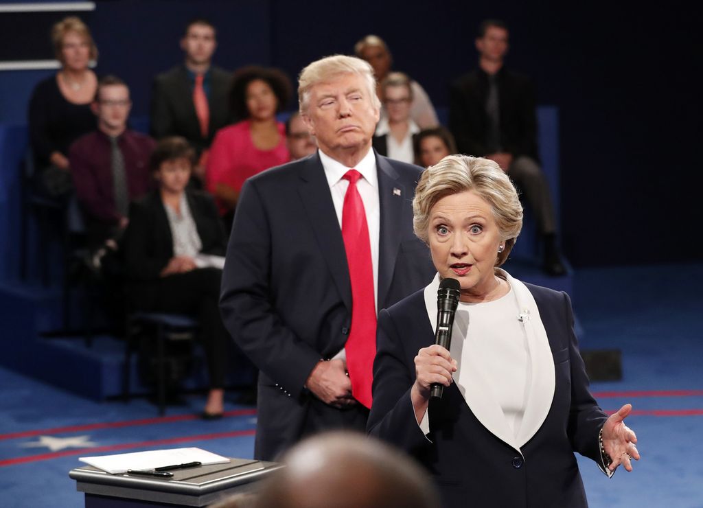 Calon presiden dari Partai Demokrat, Hillary Clinton, berbicara, sementara capres dari Republik, Donald Trump, mendengarkan pada debat capres kedua pemilu AS 2016 di St Louis, AS, 9 Oktober 2016. 