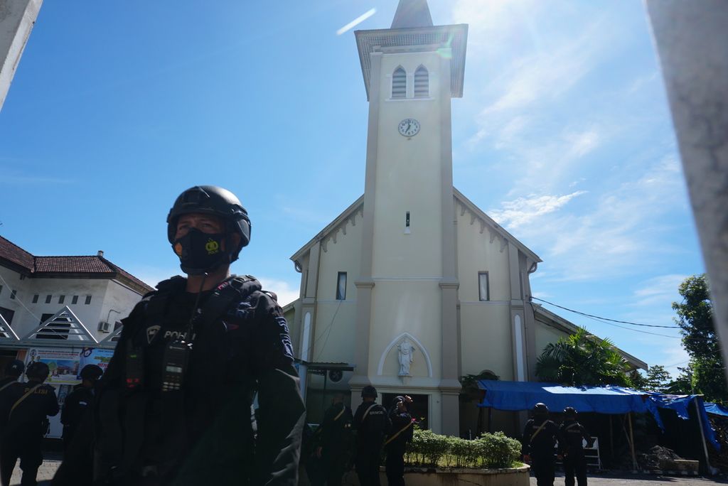 Seorang anggota Brigadir Mobil berjaga di depan Katedral Hati Yesus yang Mahakudus Makassar, Sulawesi Selatan, Senin (29/3/2021), sehari setelah ledakan bom bunuh diri pada perayaan Minggu Palma. Kepolisian telah ditugaskan untuk menjaga gereja-gereja di Makassar jelang perayaan Paskah.