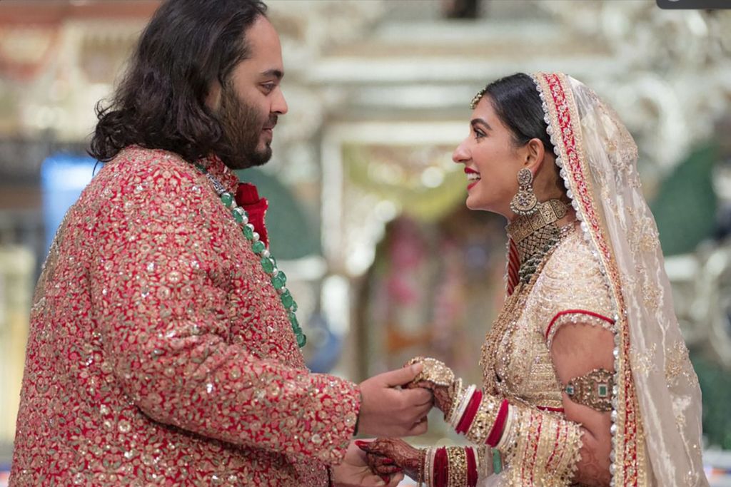 Dalam foto yang disediakan oleh Reliance Industries, Anant Ambani, kiri, putra miliarder Mukesh Ambani, berpegangan tangan dengan Radhika Merchant saat upacara pernikahan mereka di Jio World Convention Center di Mumbai, India, Jumat (12/7/2024).