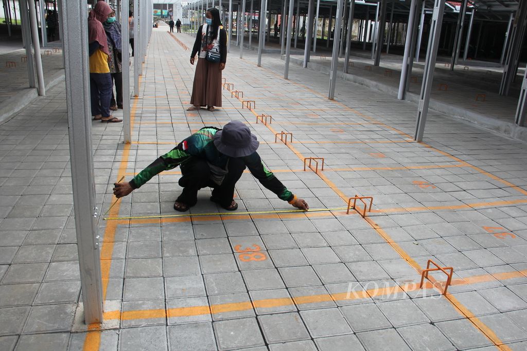Seorang pedagang kaki lima mengukur luas lapak di tempat relokasi yang diberi nama Teras Malioboro II di kawasan wisata Malioboro, Kota Yogyakarta, Selasa (1/2/2022). 