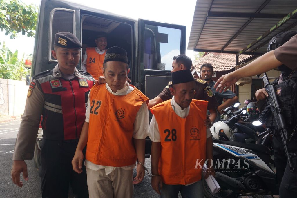 Terdakwa Slamet Tohari (kanan) dikawal untuk mengikuti sidang perdana di Pengadilan Negeri Banjarnegara, Jawa Tengah, Selasa (26/9/2023). Slamet didakwa kombinasi, mulai dari pembunuhan berencana, uang palsu, penipuan, hingga penggelapan.
