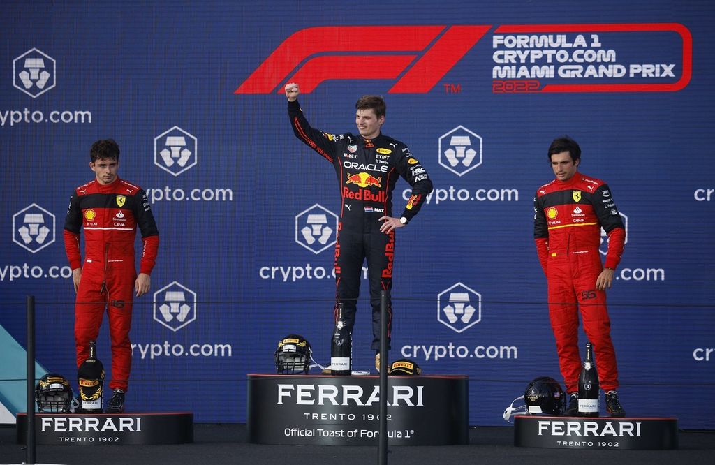 Pemenang F1 seri Miami dari tim Red Bull Max Verstappen (tengah), bersama pemenang kedua Charles Leclerc dari tim Ferrari (kiri) dan pemenang ketiga Carlos Sainz merayakan pencapaian mereka di podium Sirkuit Internasional Miami, Florida, AS, Minggu (8/5/2022). 