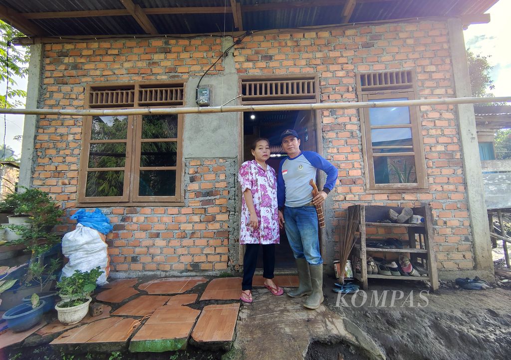 Petani penggarap kebun orang lain, Andi Purnawansyah, berpose bersama istrinya di depan kediaman mereka di kawasan Jagalan, Bangun Jaya, Pagaralam Utara, Kota Pagaralam, Sumatera Selatan, Minggu (7/7/2024). 