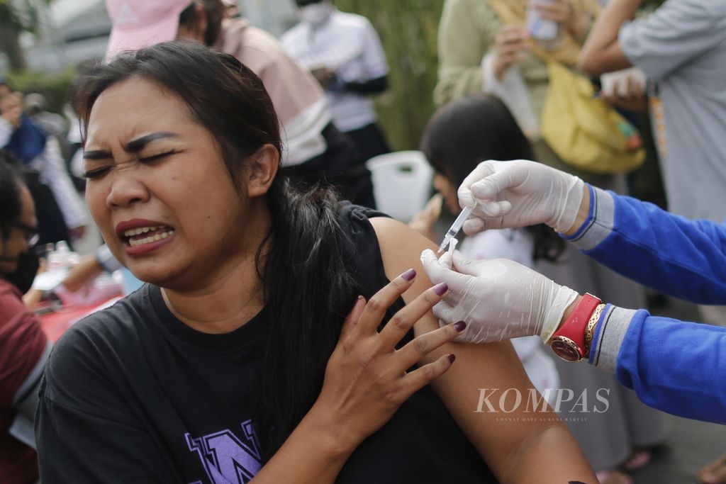 Warga menjalani vaksinasi Covid-19 di kawasan Bundaran HI, Jakarta, saat pelaksanaan hari bebas kendaraan bermotor (HBKB), Minggu (31/7/2022). Vaksinasi jemput bola yang dilakukan oleh petugas Puskesmas Johar Baru, Jakarta Pusat, ini untuk suntikan dosis pertama, kedua, dan <i>booster.</i>