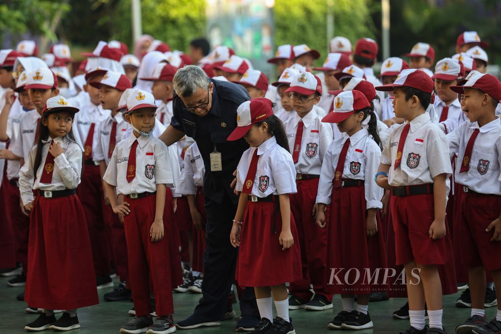 Seorang guru merapikan barisan siswa saat upacara bendera di SDN Kalibata 11, Jakarta, Senin (22/4/2024). 