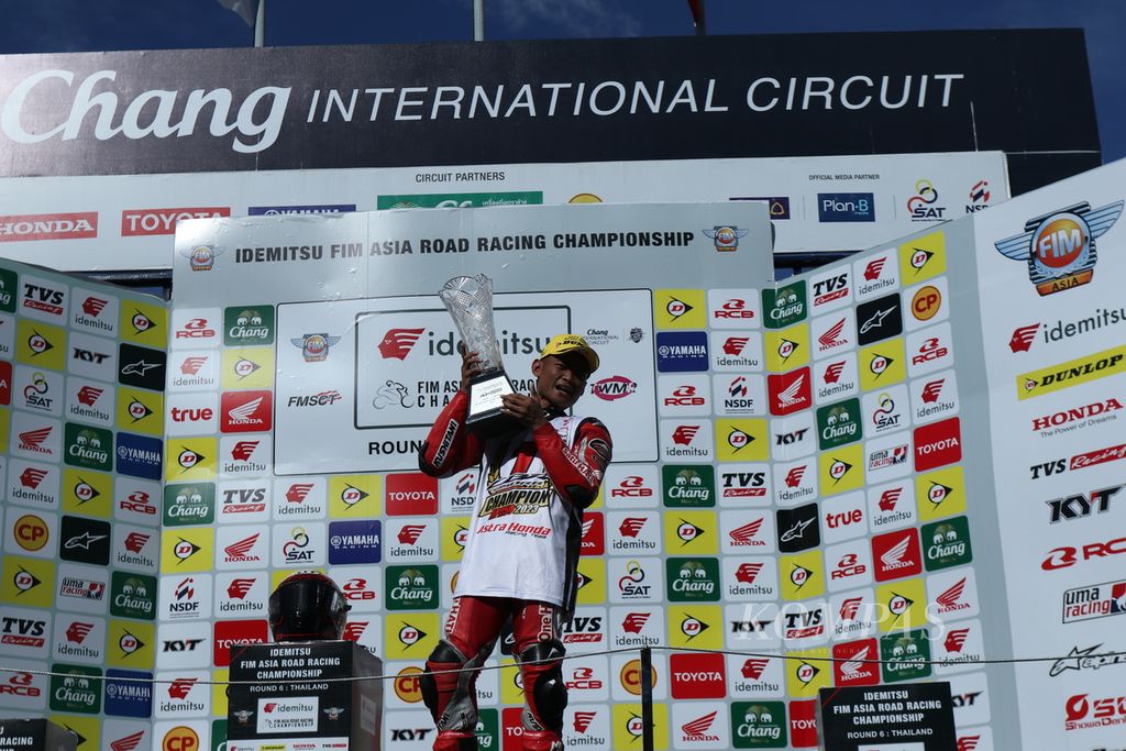 Pebalap tim Astra Honda Racing, Rheza Danica Ahrens, mengangkat trofi juara kelas Asia Production 250 dalam ajang Asia Road Racing Championship 2023 di Sirkuit Internasional Chang, Buriram, Thailand, Minggu (3/12/2023).