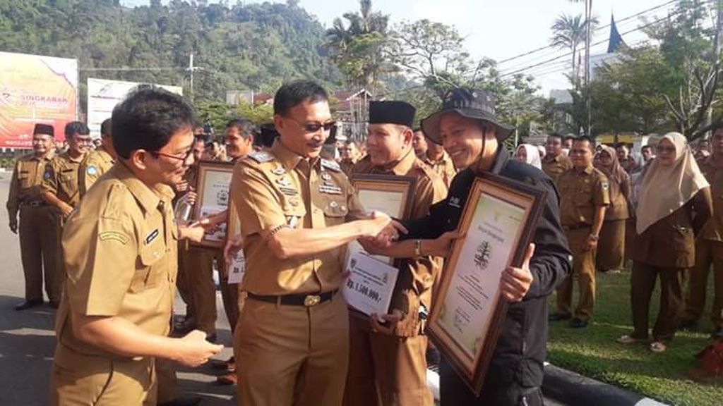 Bupati Pesisir Selatan Hendrajoni menyerahkan plakat penghargaan Kalpataru tingkat Provinsi Sumatera Barat kepada pegiat konservasi Yaparudin (kanan) di halaman kantor bupati, Senin (4/11/2019).