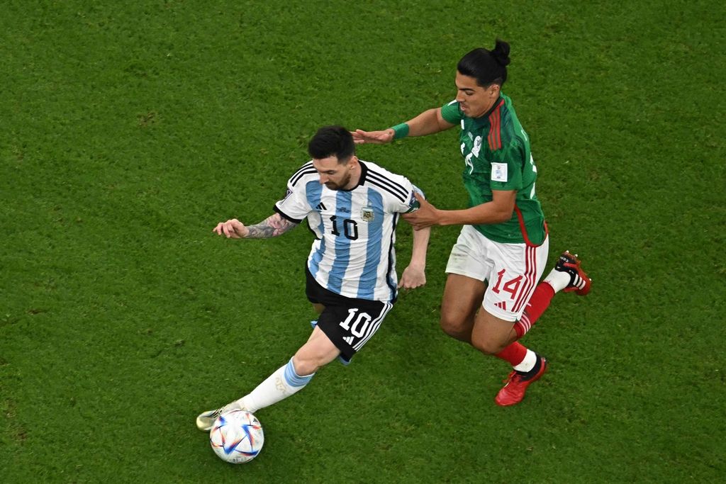 Penyerang Argentina Lionel Messi (kiri) berebut bola dengan gelandang Meksiko Erick Gutierrez pada laga penyisihan Grup C di Stadion Lusail, Doha, Minggu (27/11/2022) dini hari WIB.