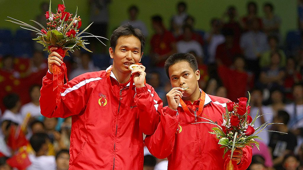  Hendra Setiawan (kiri) dan Markis Kido menggigit medali emas ganda putra bulu tangkis yang mereka raih di  Olimpiade Beijing, 16 Agustus 2008.   