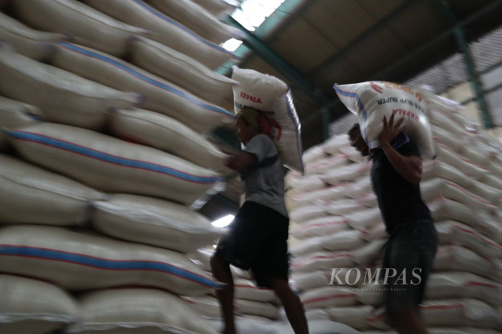 Buruh mengangkut karung beras di Pasar Induk Beras Cipinang, Jakarta, pada Agustus 2021.
