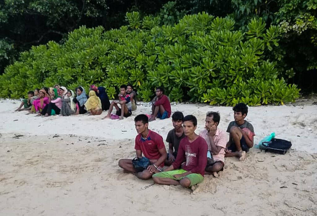 Di dalam foto yang disebarluaskan oleh Badan Penegakan Hukum Kelautan Malaysia pada 27 Juli 2022 tampak terduga warga Rohingya dari Myanmar duduk di pesisir Pulau Langkawi, Malaysia. Mereka masuk ke perairan Malaysia secara ilegal dan 26 orang di antara mereka diduga tewas tenggelam. (Photo by Handout / MALAYSIAN MARITIME ENFORCEMENT AGENCY / AFP) / RESTRICTED TO EDITORIAL USE – MANDATORY CREDIT “AFP PHOTO / Malaysian Maritime Enforcement Agency” – NO MARKETING – NO ADVERTISING CAMPAIGNS – DISTRIBUTED AS A SERVICE TO CLIENTS