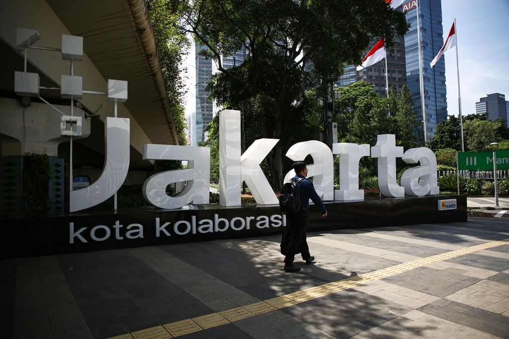Pekerja melintas di jalur pedestrian jalan protokol Jenderal Sudirman di kawasan Setia Budi, Jakarta Selatan, Senin (3/1/2022). Aktivitas perkantoran mulai kembali aktif setelah libur Tahun Baru 2022.