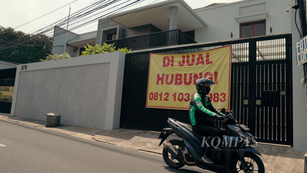 Warga melintas di depan rumah yang dijual di kawasan Cipinang, Jakarta Timur, Kamis (26/8/2021). Dampak pandemi Covid-19 membuat harga rumah seken turun karena daya beli masyarakat yang juga turun.