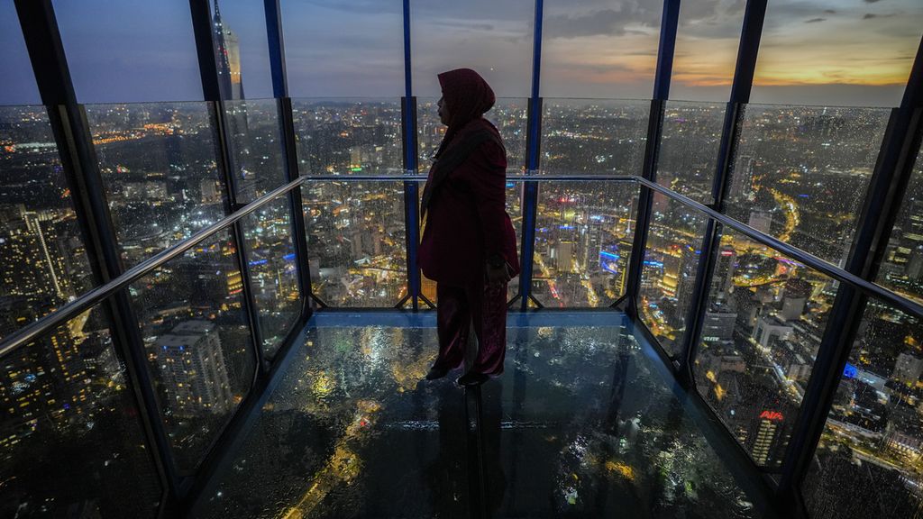 A women looks out from a observation deck as members of the Malaysian Islamic authority perform "Rukyah Hilal Ramadan," the sighting of the new moon to determine the start of the holy fasting month of Ramadan in Kuala Lumpur, Malaysia, Wednesday, March 22, 2023. During Ramadan, Muslims worldwide marked by fasting, abstaining from foods, sex and smoking from dawn to dusk. 