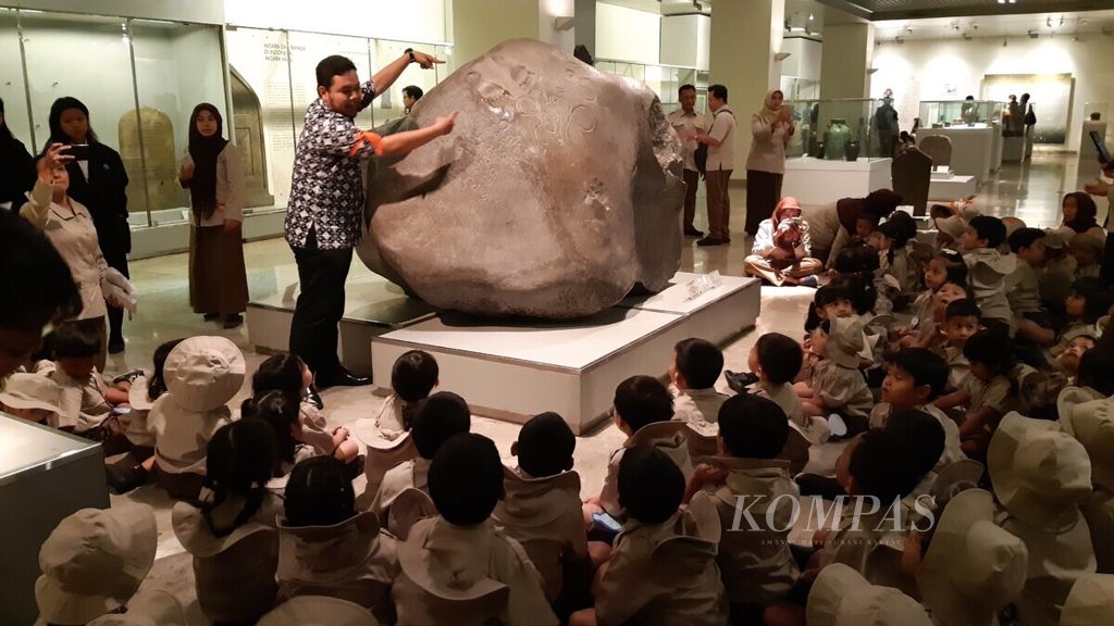 Siswa-siswa pendidikan anak usia dini mendengar penjelasan pemandu Museum Nasional mengenai Prasasti Ciaruteun dalam acara "PAUD ke Museum" di Jakarta, Rabu (14/8/2019).