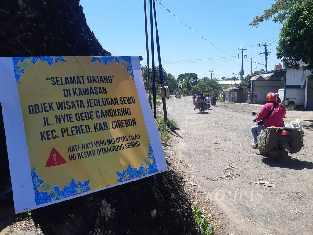 Spanduk kecil berisi sindiran terkait jalan rusak terpampang di Jalan Nyi Gede Cangkring, Kecamatan Plered, Kabupaten Cirebon, Jawa Barat, Jumat (12/5/2023). Jalan di daerah itu telah rusak bertahun-tahun. Warga pun memasang spanduk sebagai bentuk protes kerusakan jalan.