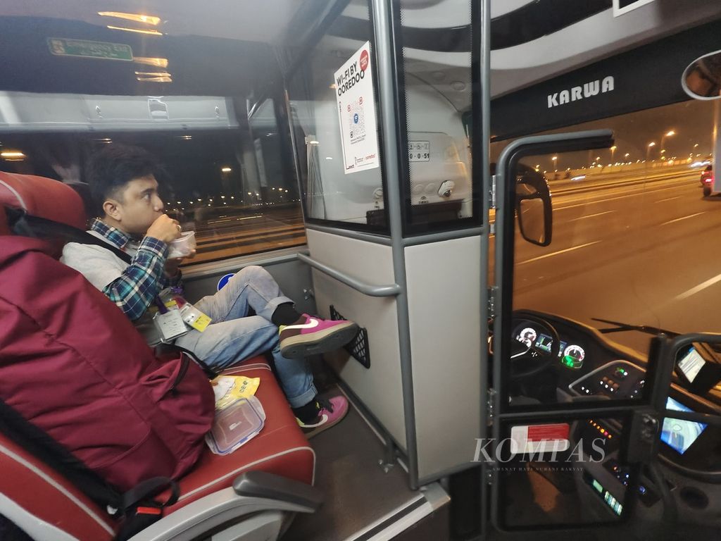 Wartawan <i>Kompas,</i> M Ikhsan Mahar, menyantap bekal di dalam bus dalam perjalanan untuk meliput salah satu pertandingan di Piala Dunia Qatar 2022.