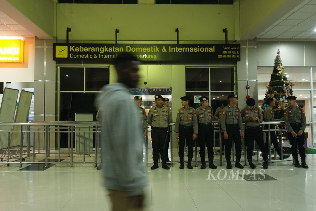 Polisi berjaga di pintu keberangkatan Bandara Sam Ratulangi, Manado, Sulawesi Utara, Selasa (10/1/2023). Bandara tersebut merupakan titik transit bagi penerbangan yang mengangkut Gubernur Papua Lukas Enembe yang baru saja ditangkap Komisi Pemberantasan Korupsi (KPK).