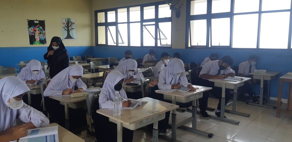 Murid kelas 7 SMP 290 Marunda, Jakarta Utara, sedang melangsungkan pembelajaran tatap muka sif 2, Senin (14/3/2022) siang. Kelas mereka berbatasan langsung dengan Pelabuhan Marunda, yang di antaranya aktif dengan aktivitas bongkar muat batubara.