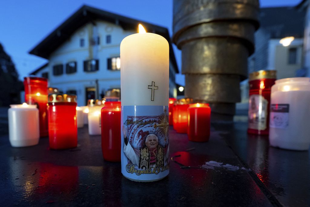 Lilin-lilin menyala diletakkan di depan rumah tempat Paus Benediktus XVI dilahirkan di Marktl, Jerman pada Minggu (1/1/2023).