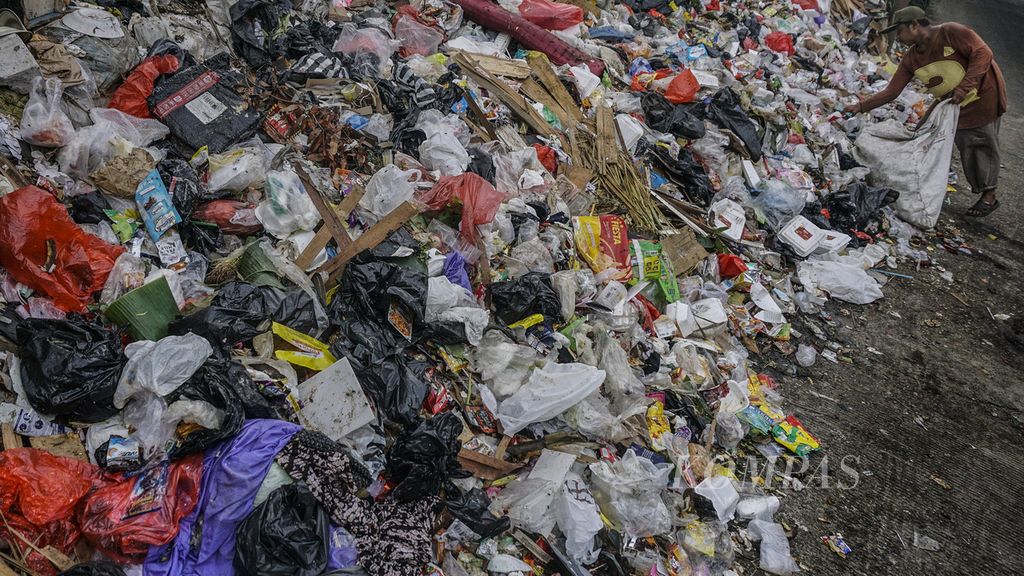Aktivitas pemulung di tumpukan sampah di tempat pembuangan sampah sementara di Jalan Babakan Tengah, Dramaga, Kabupaten Bogor, Jawa Barat, Senin (21/2/2022).