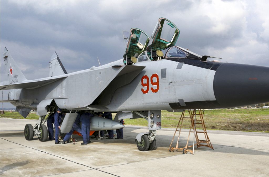 Dalam foto dari tayangan video yang dirilis Layanan Pers Kementerian Pertahanan Rusia, 15 Februari 2022, terlihat jet tempur MiG-31 milik Angkatan Udara Rusia yang membawa rudal hipersonik Kinzhal tengah diparkir di Pangkalan Udara Hmeimim, Suriah. 
