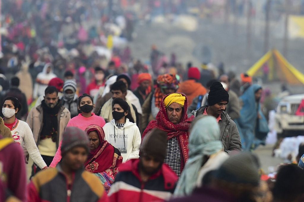 Ribuan umat Hindu tiba untuk mengikuti ritual mandi suci pada perayaan festival Makar Sankranti selama festival tahunan Hindu 'Magh Mela' di Sangam pertemuan Sungai Gangga, Yamuna, dan Saraswati di Allahabad, India, Jumat (14/1/2022). 