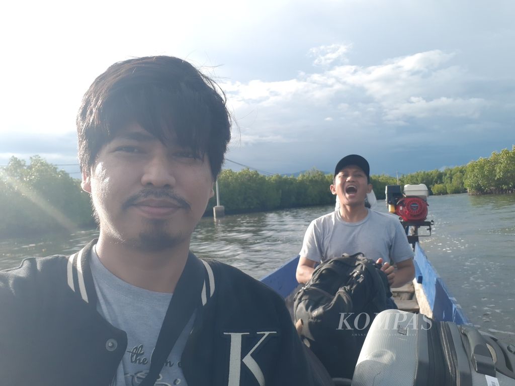 Jurnalis <i>Kompas</i>, Abdullah Fikri Ashri (kiri), dan pewarta foto <i>Kompas</i>, Heru Sri Kumoro, menaiki perahu menuju perkampungan terapung suku Bajo, Desa Torosiaje, Kecamatan Popayato, Kabupaten Pohuwato, Gorontalo, Kamis (14/7/2022).
