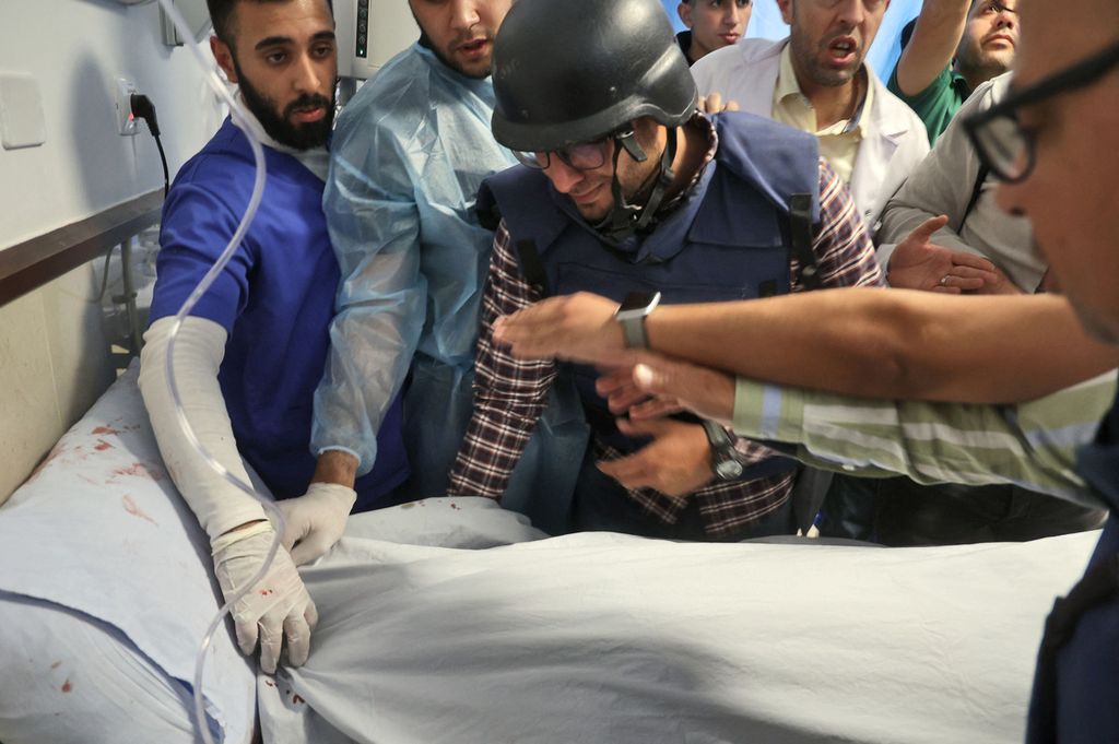 Juru kamera Palestina Mujahed al-Saadi (Tengah) dari Palestine Today TV berkabung dengan wartawan lainnya atas jasad reporter veteran Al-Jazeera Shireen Abu Aqleh (Akleh), yang ditembak mati saat meliput penggerebekan di kamp pengungsi Jenin di Tepi Barat, pada 11 Mei 2022, di rumah sakit di Jenin.  