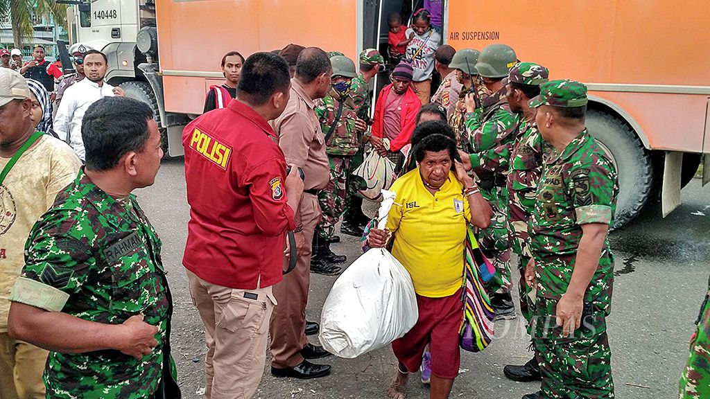 Warga   dari empat kampung di Distrik Tembagapura, Papua, turun dari bus setelah dievakuasi ke Timika pada Senin (20/11). Sebanyak 804 warga  dievakuasi kemarin.  
