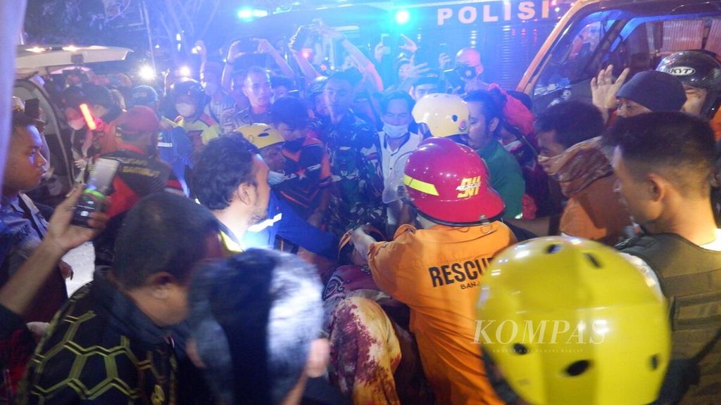 Proses evakuasi korban dari reruntuhan bangunan rumah toko tiga lantai Alfamart di Kecamatan Gambut, Kabupaten Banjar, Kalimantan Selatan, Senin (18/4/2022) malam. Hingga Selasa (19/4) pukul 08.00 Wita, 9 korban ditemukan selamat, 3 meninggal, dan 1 masih dalam pencarian.