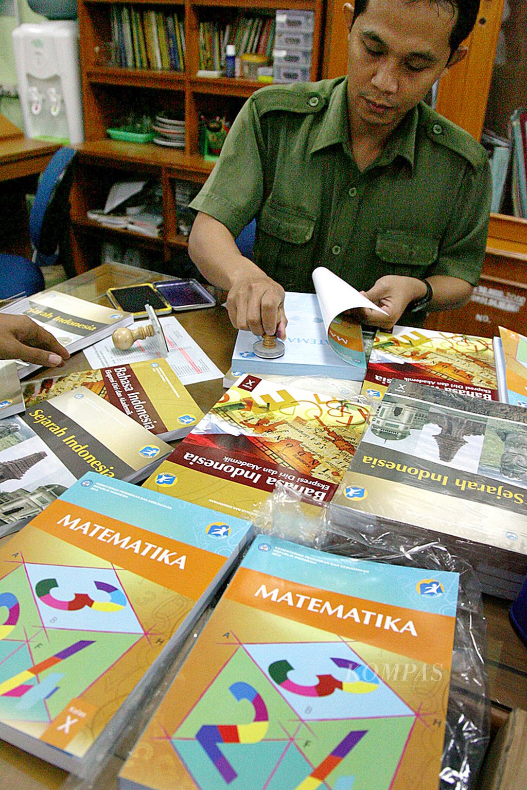 Sabar Iman, pegawai perpustakaan SMAN 68 Jakarta, menyiapkan buku-buku pelajaran kurikulum 2013 