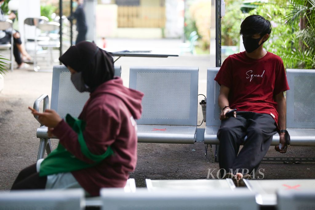  Warga mengenakan masker dan menjaga jarak sosial saat menunggu antrean berobat di Puskesmas Larangan Utara, Kota Tangerang, Banten, Rabu (28/4/2020). Puskesmas tersebut memindahkan layanan pemeriksaan bagi pasien yang memiliki gejala flu dan demam ke bagian luar gedung guna mengantisipasi penyebaran virus korona baru. Selain itu, puskesmas ini juga memberikan layanan konsultasi kesehatan berbasis daring guna mengurangi kontak langsung dengan pasien sebagai langkah antisipasi.