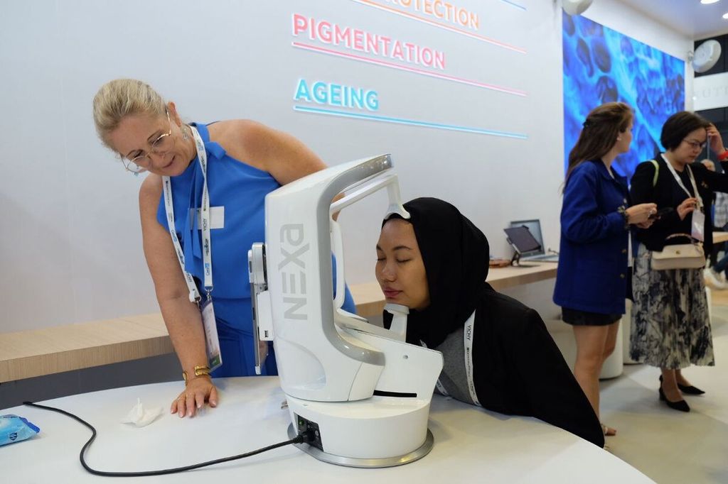 Pengunjung mencoba teknologi kecantikan Effaclar Spotscan atau pemeriksaan kesehatan kulit dengan bantuan alat kecerdasan buatan (<i>artificial intelligence</i>) yang dipamerkan di stan L’Oreal selama acara World Congress of Dermatology 2023, di Singapura, 3-8 Juli 2023.