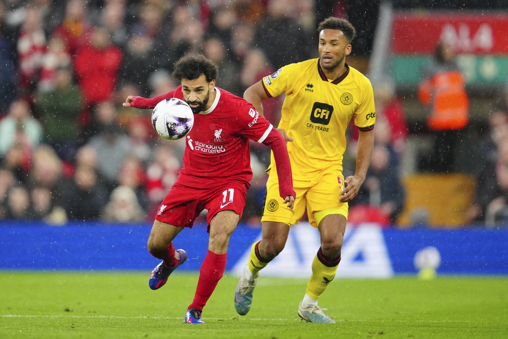 Pemain Liverpool, Mohamed Salah (kiri), mencoba melewati pemain Sheffield United, Auston Trusty, dalam laga lanjutan Liga Inggris di Stadion Anfield, Liverpool, Inggris, Jumat (5/4/2024) dini hari. Liverpool menang secara meyakinkan atas Sheffield United dengan skor 3-1.