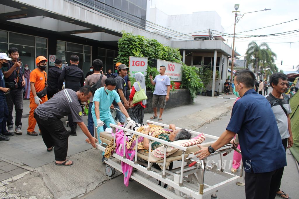 Seorang pasien dibawa kembali ke dalam Rumah Sakit Umum Daerah Sumedang, Jawa Barat, Senin (1/1/2024), setelah bertahan semalam sebelumnya di tenda darurat karena daerah tersebut dilanda gempa.