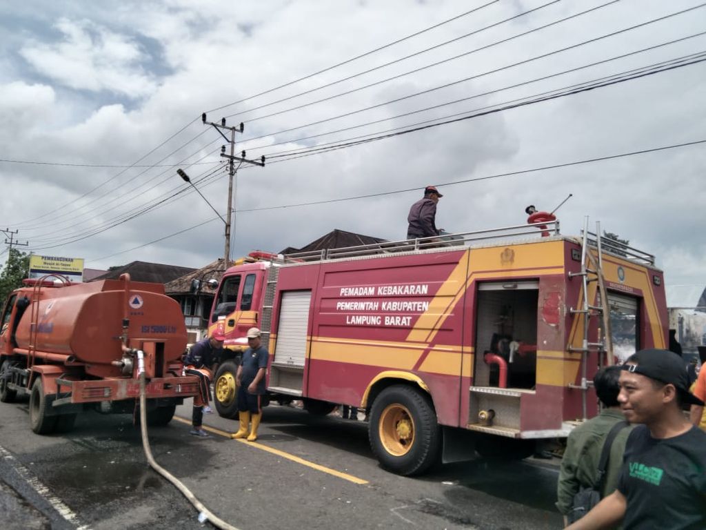 Mobil pemadam kebakaran berupaya memadamkan tiga rumah panggung milik warga di Pekon Kenali, Kecamatan Belalau, Kabupaten Lampung Barat, Lampung, yang terbakar pada Jumat (22/7/2022). 