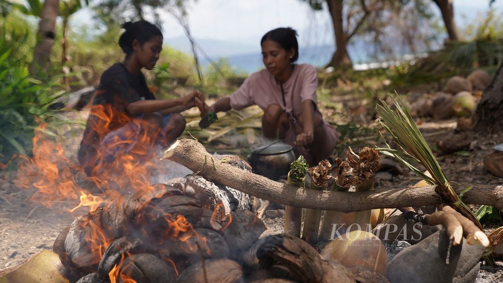 Dua perempuan menunggu masakan matang dalam pelatihan kewirausahaan pengembangan pangan lokal di Sekolah Agro Sorgum, Desa Pajinian, Kecamatan Adonara Barat, Kabupaten Flores Timur, Nusa Tenggara Timur, Selasa (8/8/2023). 